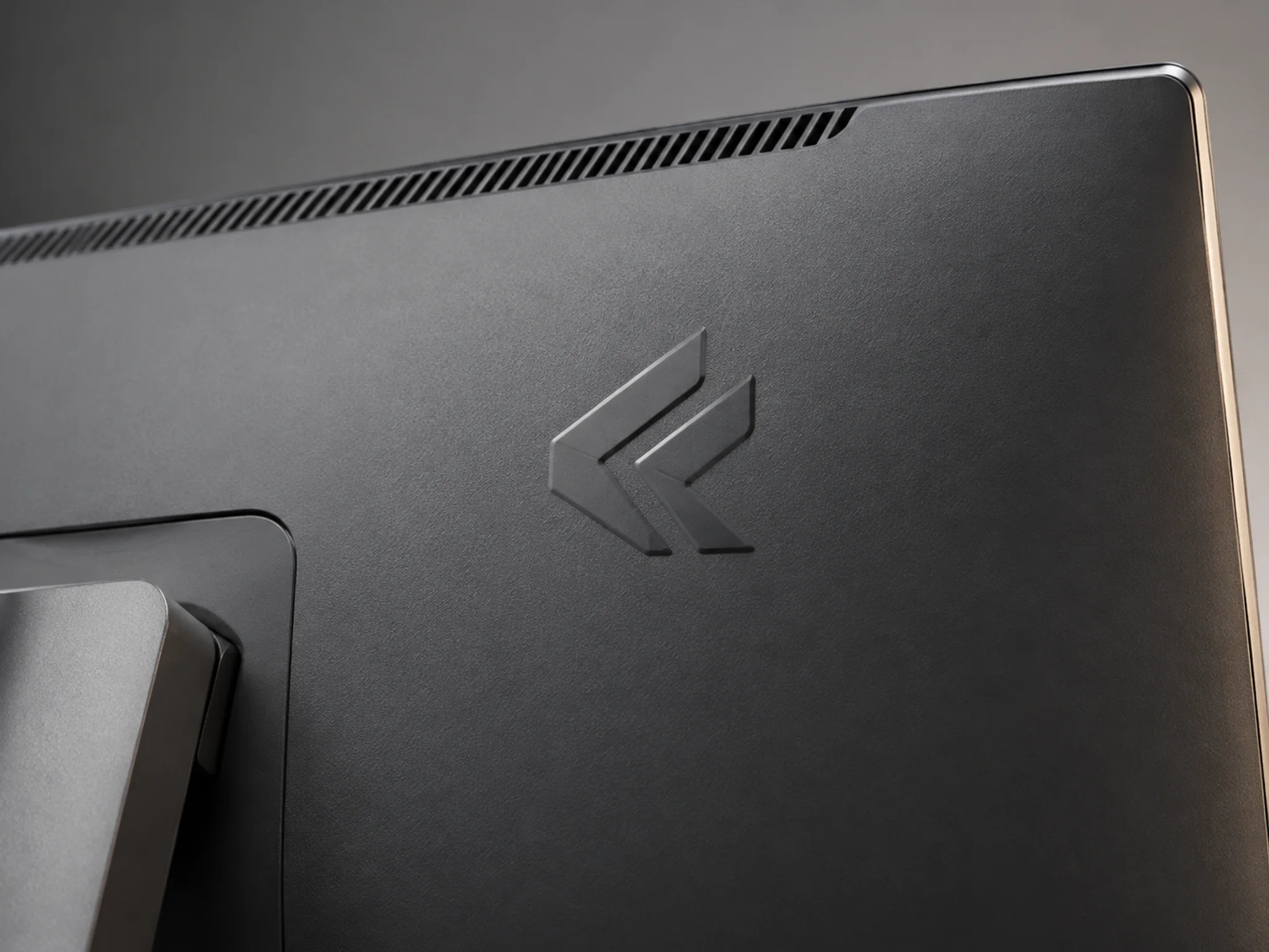 Raised molded logo formed as part of a textured monitor rear cover
